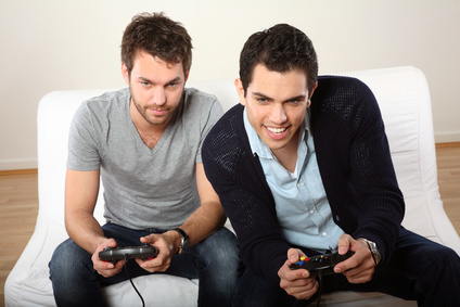 zwei maenner lachen und spielen Computerspiel